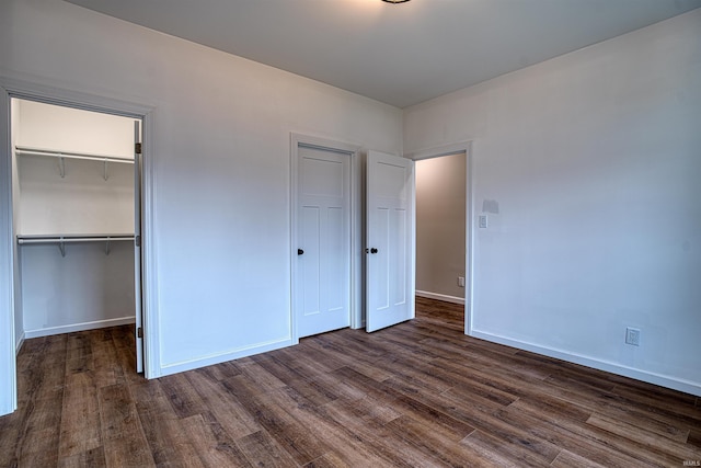 unfurnished bedroom with dark hardwood / wood-style flooring and a closet