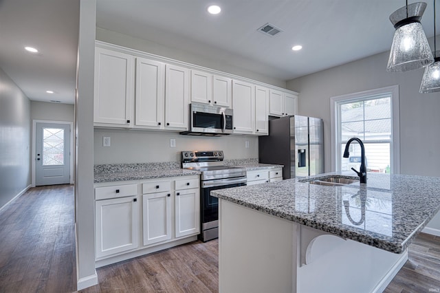 kitchen with a kitchen island with sink, sink, white cabinetry, wood-type flooring, and stainless steel appliances