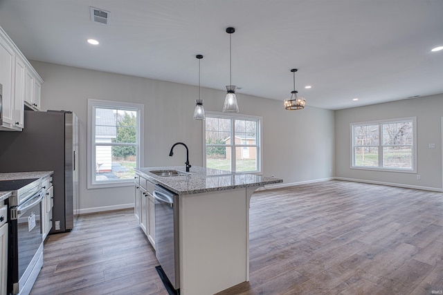 kitchen featuring sink, hanging light fixtures, an island with sink, white cabinetry, and stainless steel appliances