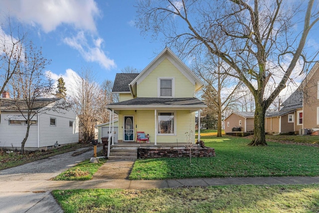 bungalow-style home with covered porch, a garage, and a front yard