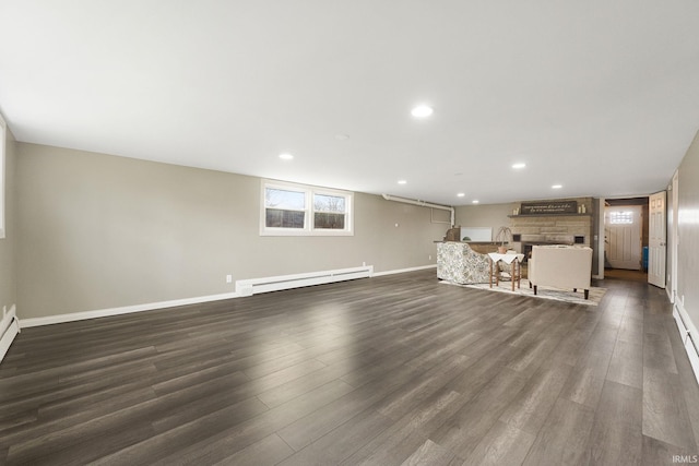 unfurnished living room featuring a fireplace, dark hardwood / wood-style flooring, and a baseboard radiator