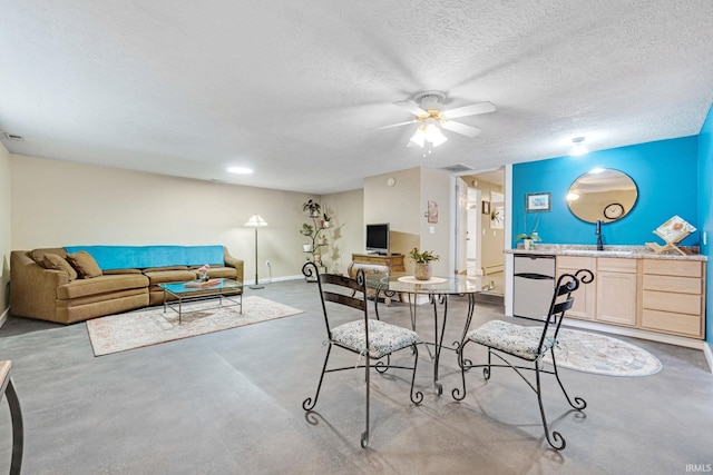 dining room featuring a textured ceiling, ceiling fan, and sink