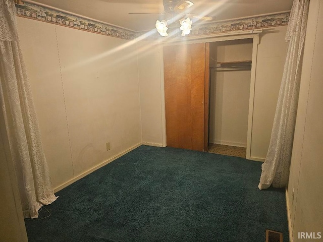 unfurnished bedroom featuring a closet, dark carpet, and ceiling fan