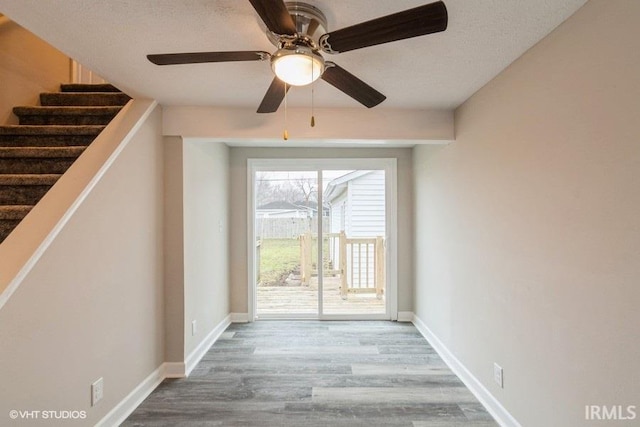 doorway to outside with wood-type flooring and ceiling fan