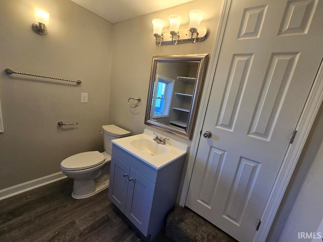 bathroom featuring toilet, vanity, and hardwood / wood-style flooring