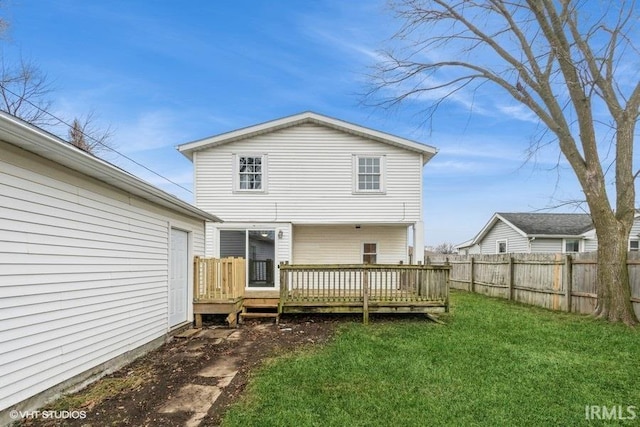 rear view of house featuring a yard and a wooden deck