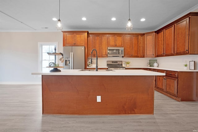 kitchen with appliances with stainless steel finishes, light hardwood / wood-style flooring, pendant lighting, and sink