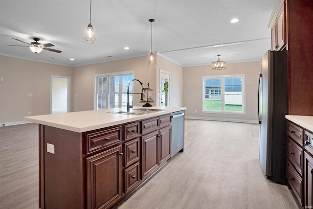 kitchen featuring sink, decorative light fixtures, a center island with sink, and appliances with stainless steel finishes