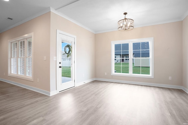 interior space with a chandelier, wood-type flooring, and ornamental molding