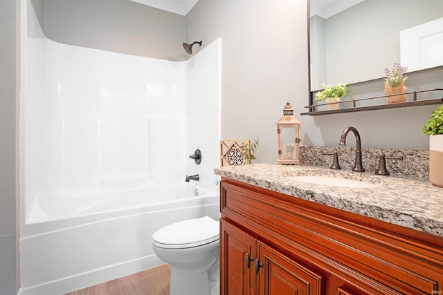 full bathroom with crown molding, hardwood / wood-style floors, toilet, vanity, and bathtub / shower combination