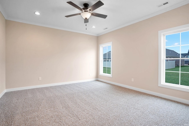 carpeted spare room featuring plenty of natural light, crown molding, and ceiling fan