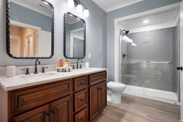 bathroom featuring walk in shower, wood-type flooring, toilet, vanity, and ornamental molding