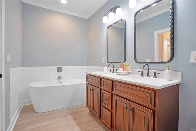 bathroom featuring a bathing tub, crown molding, vanity, and wood-type flooring