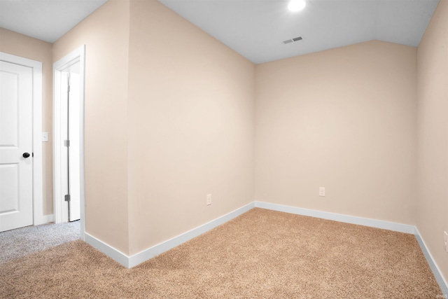 carpeted spare room with lofted ceiling