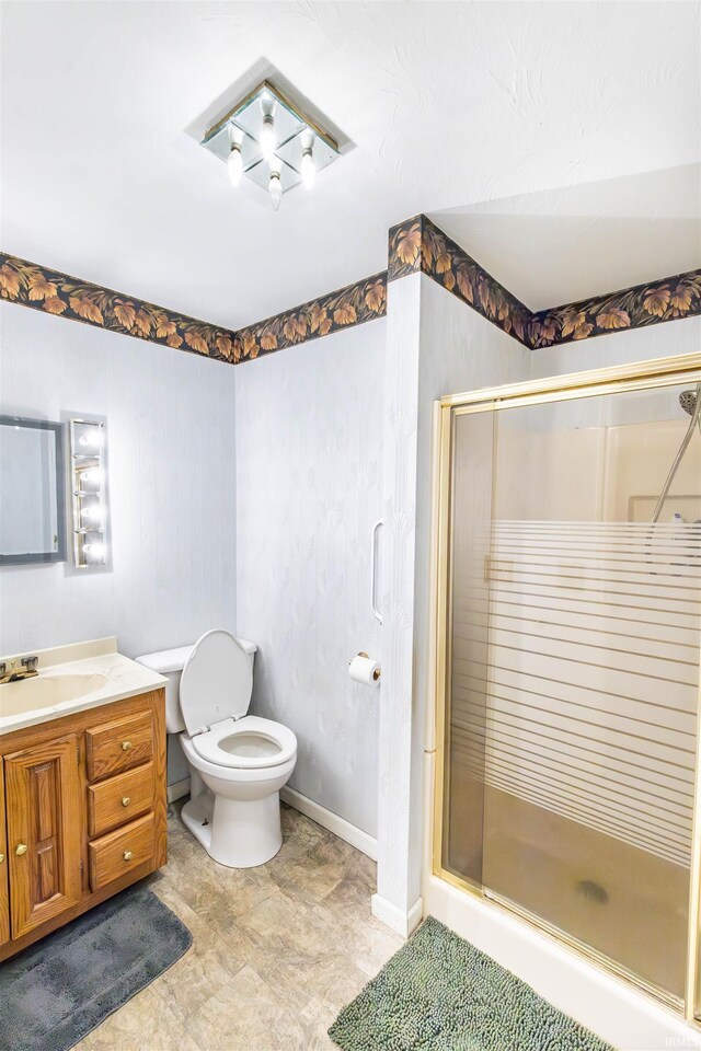 bathroom with vanity, toilet, and an enclosed shower