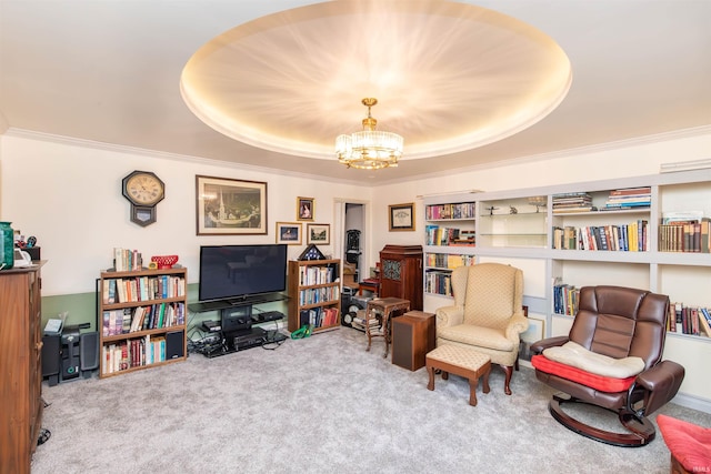 sitting room with a raised ceiling, built in features, a notable chandelier, crown molding, and carpet