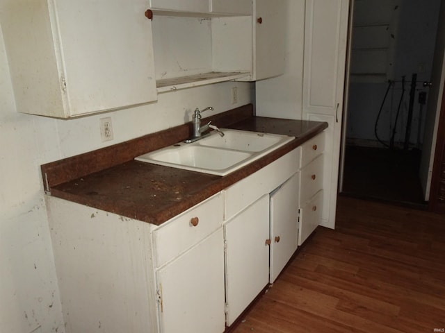 kitchen with white cabinets, wood-type flooring, and sink