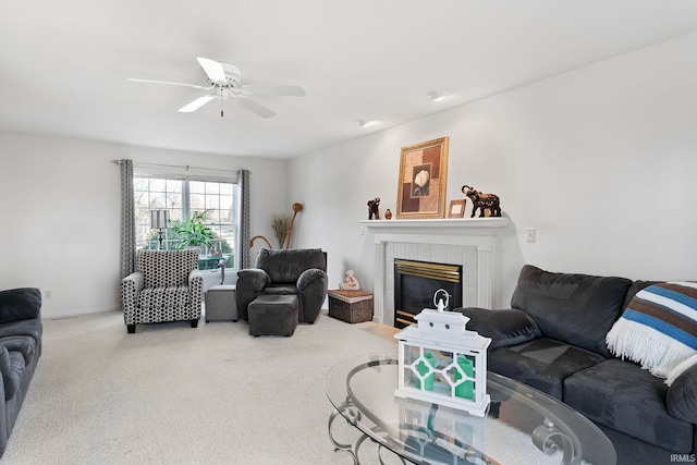 living room featuring carpet, ceiling fan, and a tiled fireplace