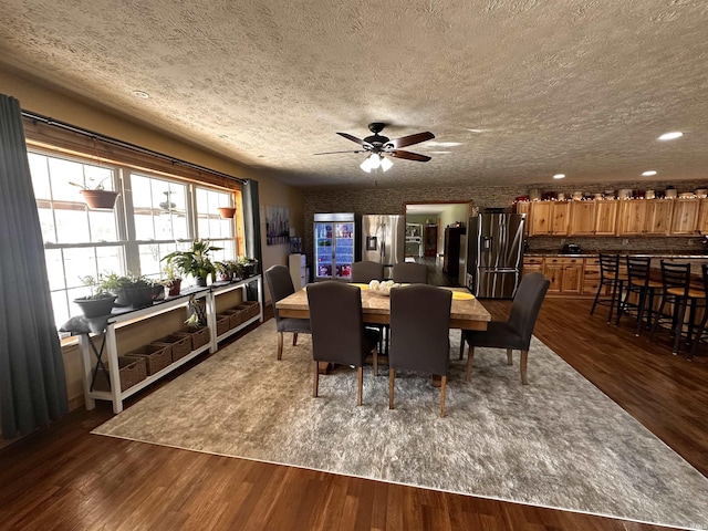 dining area with dark hardwood / wood-style floors, ceiling fan, and a textured ceiling