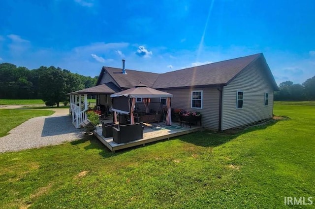 rear view of property featuring a gazebo, a yard, and a deck