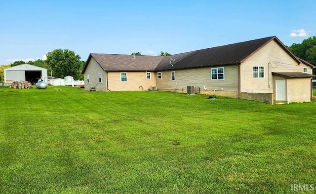 back of house with a yard and central air condition unit