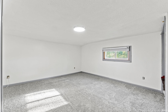 carpeted spare room with a textured ceiling