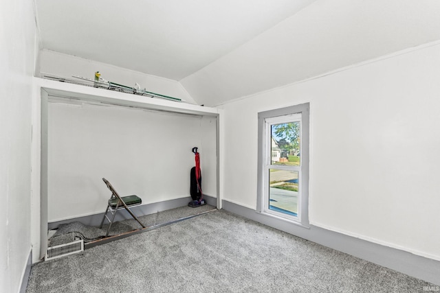 carpeted spare room featuring lofted ceiling