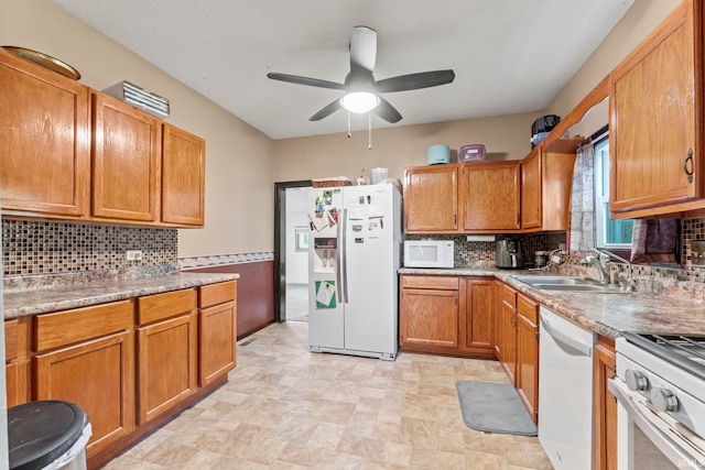 kitchen with backsplash, ceiling fan, sink, and white appliances