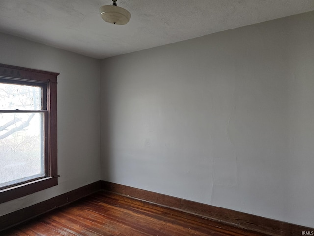 spare room with dark wood-type flooring