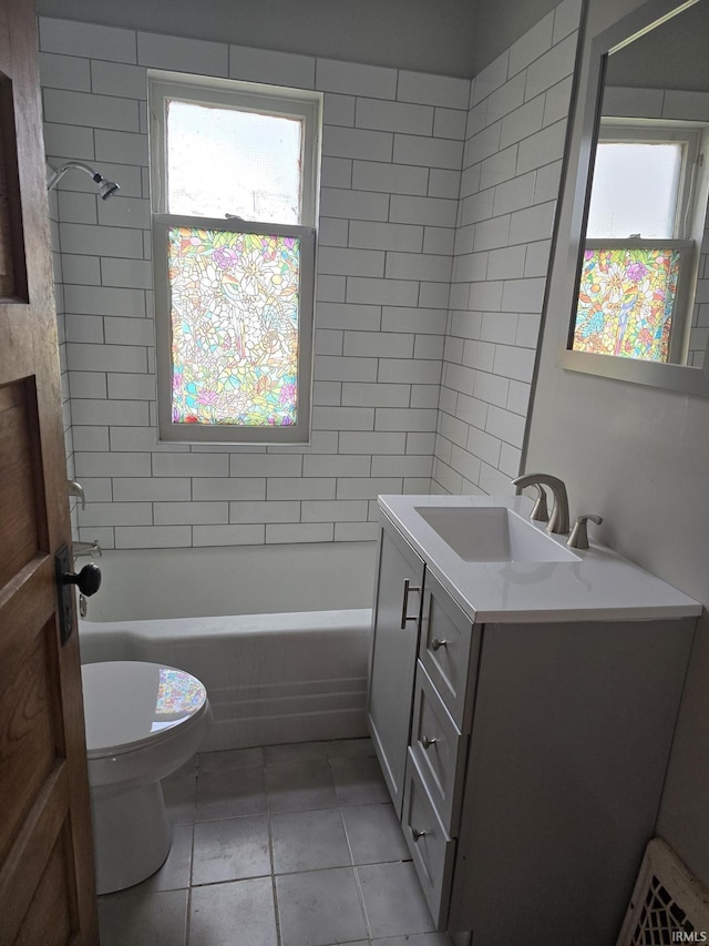 full bathroom featuring tile patterned flooring, vanity, toilet, and tiled shower / bath