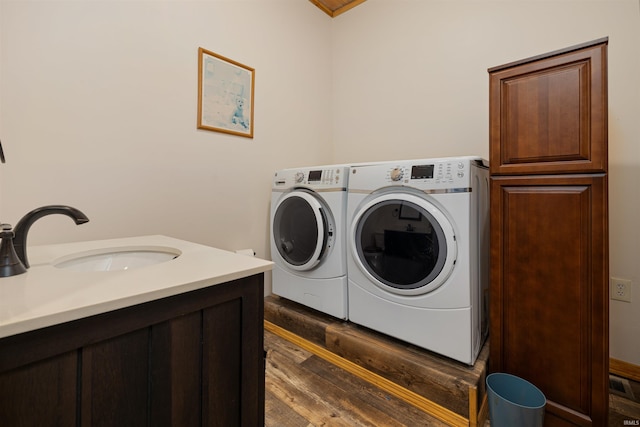 laundry room featuring crown molding, washing machine and dryer, sink, and dark wood-type flooring