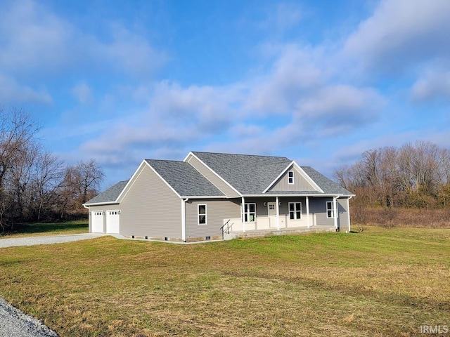 view of front of home featuring covered porch, a garage, and a front lawn