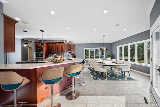 kitchen featuring stainless steel appliances, hanging light fixtures, and a breakfast bar area