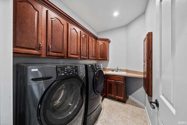 laundry area with washing machine and clothes dryer, sink, light tile patterned floors, and cabinets