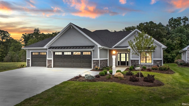 craftsman inspired home with a garage and a yard