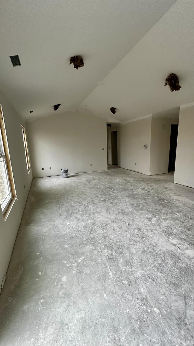 unfurnished room with vaulted ceiling