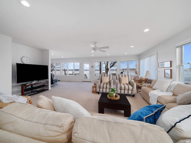 carpeted living room with ceiling fan