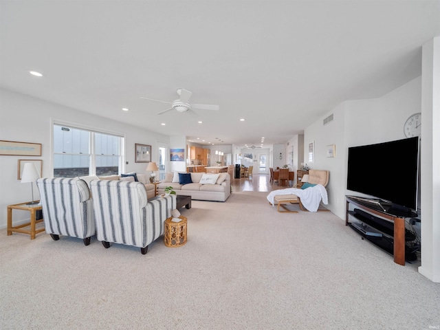 living room featuring light colored carpet, a wealth of natural light, and ceiling fan