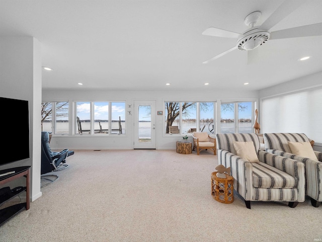 carpeted living room with ceiling fan