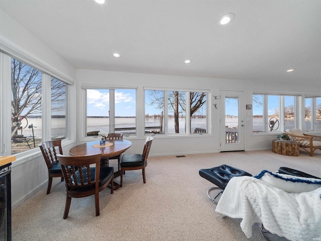 sunroom / solarium featuring a water view