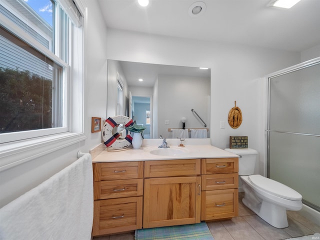 bathroom featuring a healthy amount of sunlight, tile patterned flooring, toilet, a shower with door, and vanity