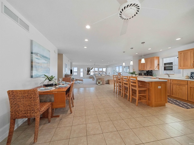 dining room with light tile patterned floors, ceiling fan, and sink