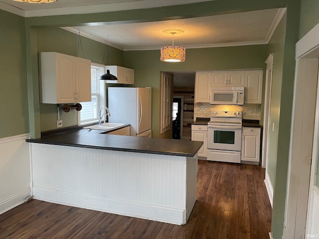 kitchen featuring kitchen peninsula, white appliances, sink, decorative light fixtures, and white cabinetry