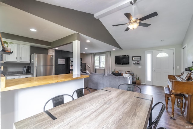 dining room with vaulted ceiling with beams, ceiling fan, and dark wood-type flooring