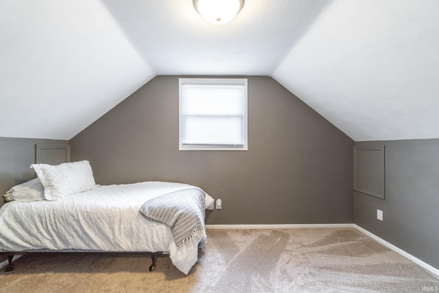 carpeted bedroom with lofted ceiling