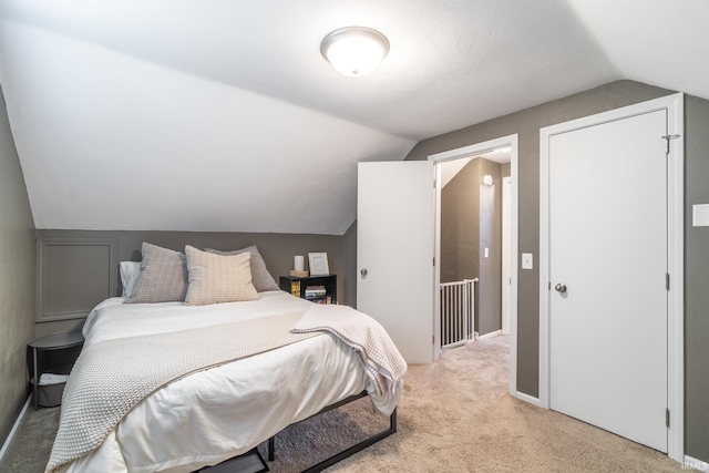 carpeted bedroom with lofted ceiling