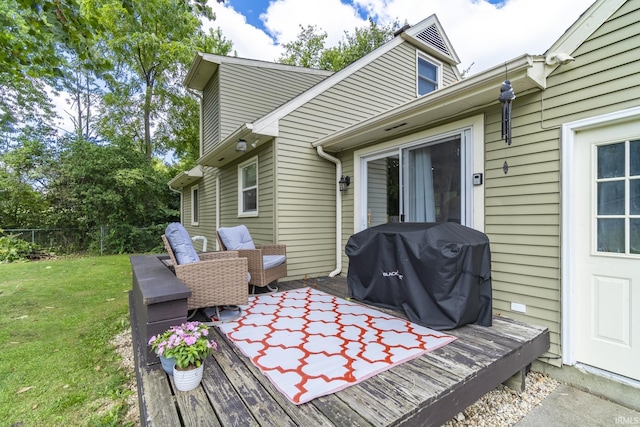 wooden terrace with a lawn and area for grilling