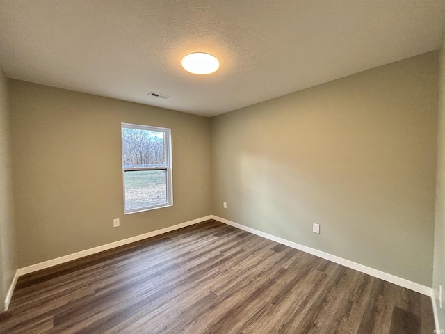 unfurnished room featuring a textured ceiling and dark wood-type flooring