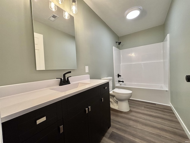 full bathroom with hardwood / wood-style flooring, vanity, bathtub / shower combination, and toilet