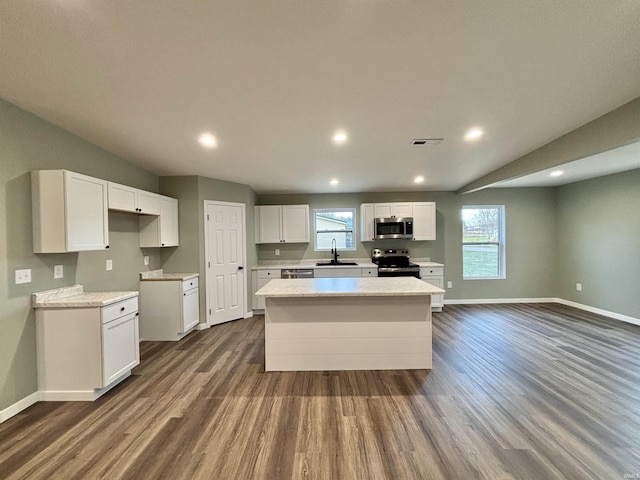 kitchen featuring a center island, stainless steel appliances, white cabinetry, and dark wood-type flooring